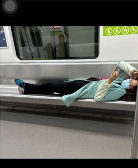 女子横躺玩手机 小伙“地铁盖被”